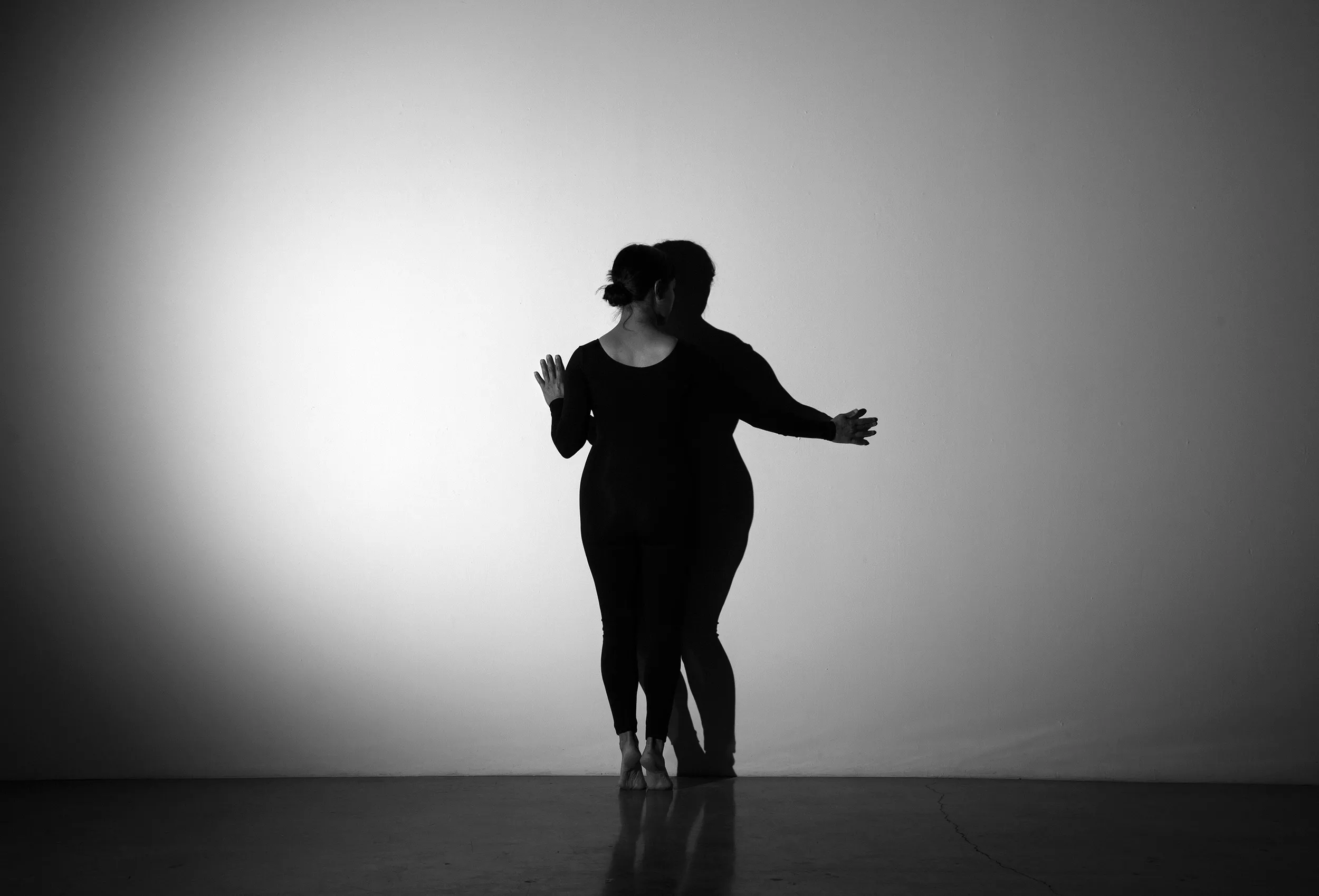 Two people dancing in front of the spotlight.